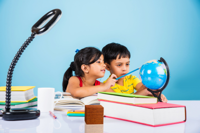 kids studying on study table with pile of books